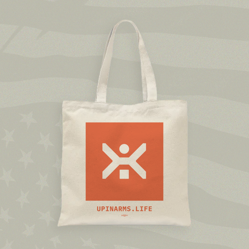 Tote bag with a red square logo and 'UPINARMS.LIFE' text on a light gray background
